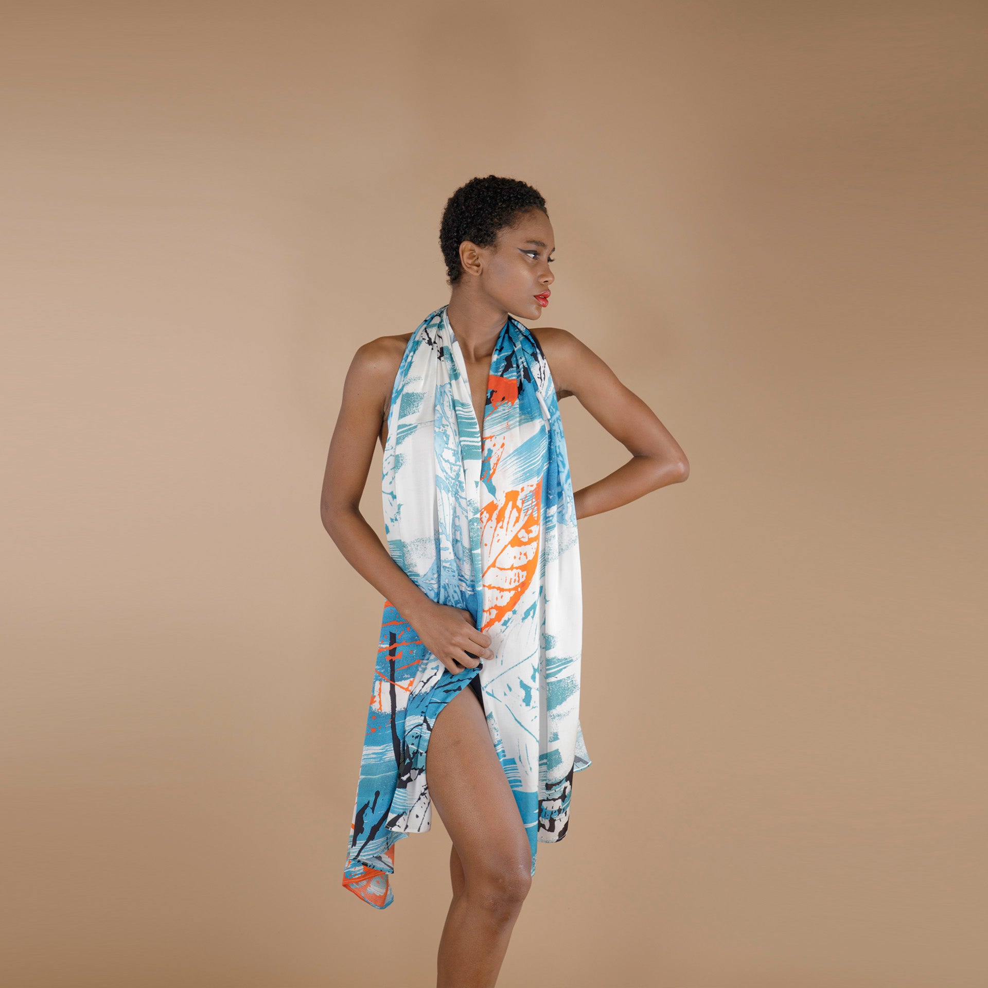 Global Small Size Model Wearing printed Rose Petal Fabric Scarf. The scarf is printed in Shade of Blue orange and white with hand painted leafy print. 