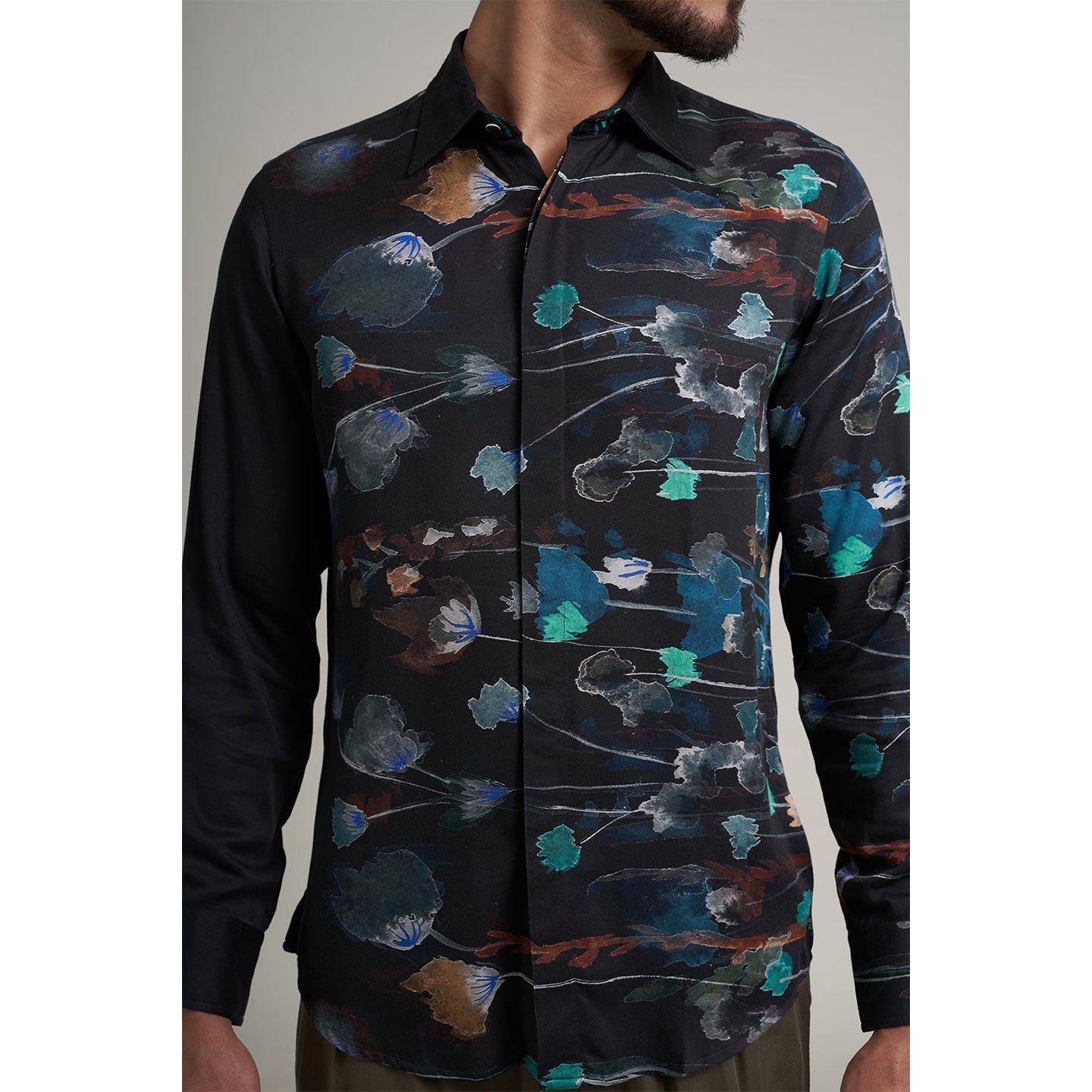 The printed Black floral organic lotus fabric shirt offers an interpretation of a timeless piece with a modern take. Made from a soft lotus stem silk fabric, It displays a comfortable fit and a rounded curved hemline featuring a placement floral pattern with one sleeve in solid and other sleeves in print, inspired by the  wilderness